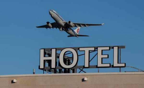 An aeroplane passes over the Sofitel hotel at Heathrow Airport