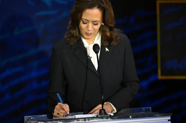 US Vice President and Democratic presidential candidate Kamala Harris takes notes as former US President and Republican presidential candidate Donald Trump speaks during a presidential debate at the National Constitution Center in Philadelphia, Pennsylvania, on September 10, 2024.